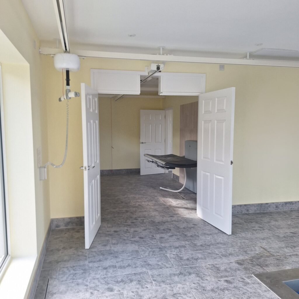 Ceiling track hoist providing smooth, supported access into the pool